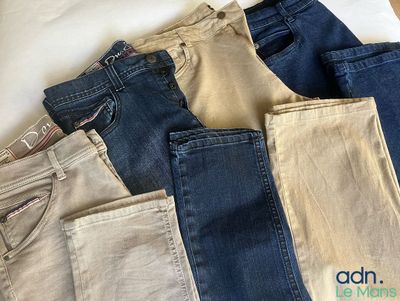 plusieurs paires de jeans posées les unes à côté des autres sur un lit