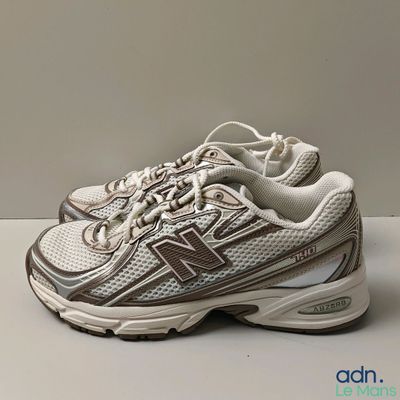 Les chaussures New Balance sont blanches et marron, avec des touches de marron.