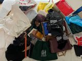 a pile of clothes and bags sitting on a bed