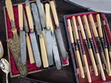 many different types of knives and spoons in a box