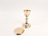 a close up of a gold chalicet and a gold egg