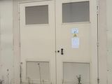 un bâtiment blanc avec deux portes et une enseigne dessus