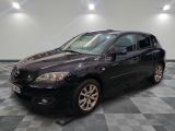 une photo d'une Mazda noire garée sur un sol à damier