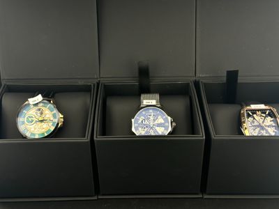 trois montres sont posées dans une boîte noire sur une table