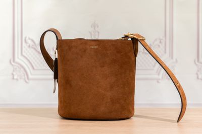 un sac à bandoulière en daim marron posé sur une table en bois