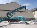 a blue crane that is sitting in front of a building