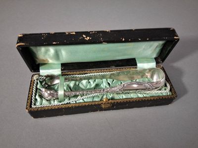 une cuillère en argent dans une boîte noire posée sur une table