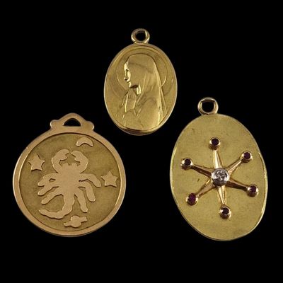 three gold medallions with a woman and a cross on them