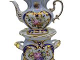 a tea pot and two cups stacked on top of each other