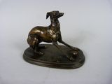 statue d'un chien assis sur un socle posé sur une surface blanche