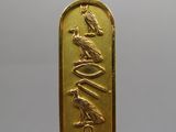 un pendentif plaqué or orné d'un symbole égyptien