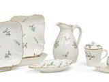 quatre assiettes en porcelaine et un pichet posés sur une table
