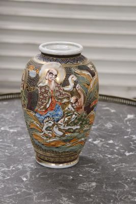 un vase avec un tableau posé sur une table