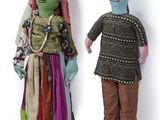 two dolls of a man and a woman standing next to each other