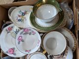 a box full of tea cups and saucers
