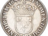 a close up of a silver coin with a crown on it