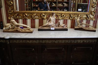 trois statues posées sur une table devant un miroir