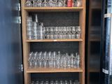 une grande étagère en bois remplie de verres et de verres à vin