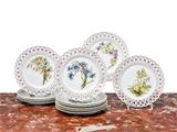 cinq assiettes ornées de fleurs, posées sur une table