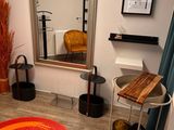 a room with a mirror, a chair, a table, and a rug