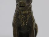 bronze figurine of a dog sitting on a white surface