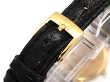 an image of a watch with a gold buckle on a black strap