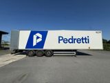 Le semi-remorque est garé sur le parking à côté du bâtiment.