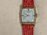 une image représentant une montre rouge avec un cadran blanc et un bracelet rouge