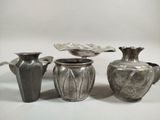 three silver vases sitting next to each other on a table
