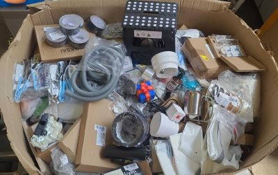 une boîte remplie d'appareils électroniques et d'autres objets posée sur la table
