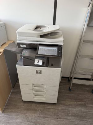 a printer sitting on top of a filing cabinet next to a ladder