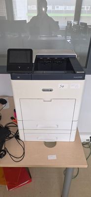 a printer sitting on top of a table with a laptop on it