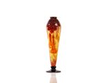 a red and yellow vase sitting on a white surface
