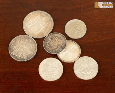 quelques pièces de monnaie sont posées sur une table en bois, sur fond marron
