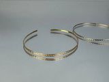 two bang bracelets on a table with a white background