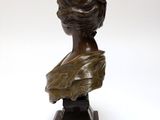 bronze bust of a woman holding a bird on a marble base