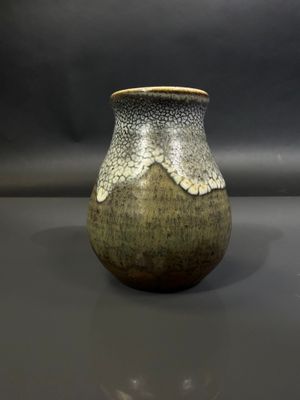 un vase posé sur une table à fond gris