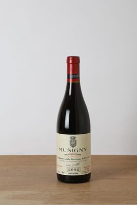 a bottle of red wine sitting on top of a wooden table