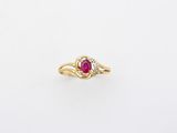 a gold ring with a ruby stone in the center