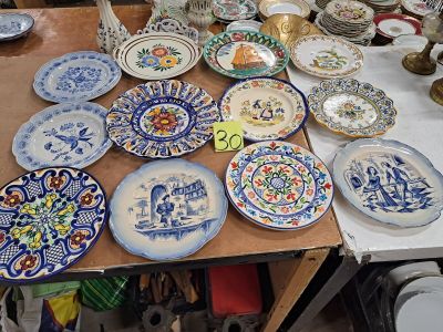 de nombreuses assiettes sur une table, aux motifs très variés