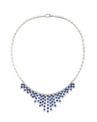 un gros plan d'un collier orné de pierres bleues sur fond blanc