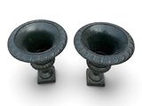 two black vases sitting next to each other on a white surface