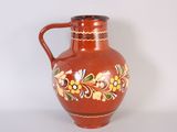 a red vase with a floral design on it