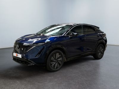 un SUV Nissan bleu garé dans une pièce aux murs blancs