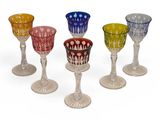 four different colored glass goblets sitting on top of each other