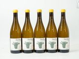quatre bouteilles de vin sont alignées sur une surface blanche