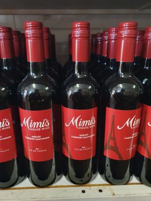 De nombreuses bouteilles de vin sont alignées sur une étagère dans un magasin.