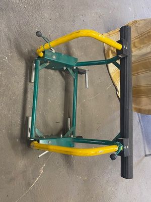 a picture of a green and yellow ladder on a concrete floor
