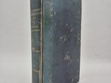 an old book sitting on top of a white surface