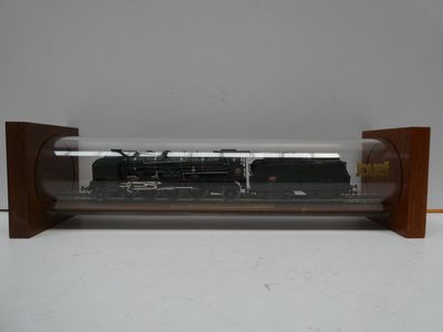 un train miniature dans une vitrine posée sur une table